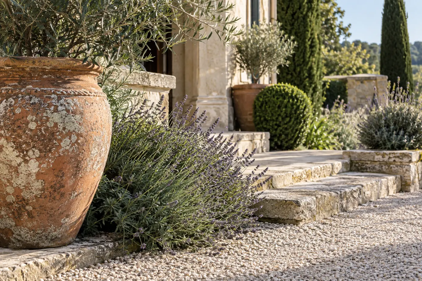 Weathered terracotta, settled pale gravel and aged limestone softened by lavender